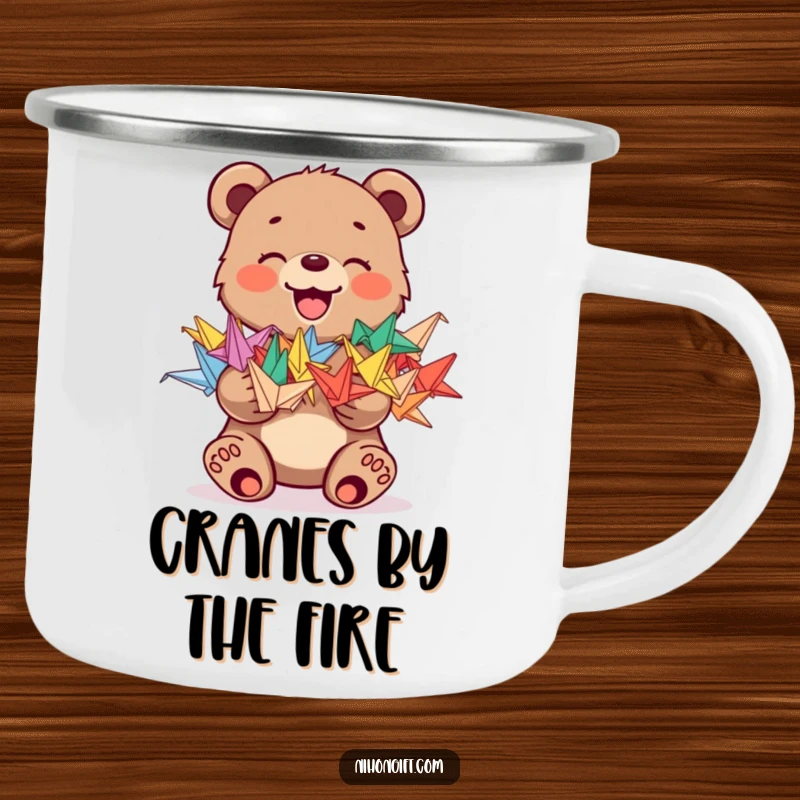 Funny camping mug with a joyful bear cub holding a stack of colorful origami cranes, designed for outdoor fun.